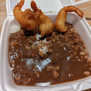 Fried shrimp with rice, beans, and gravy.
