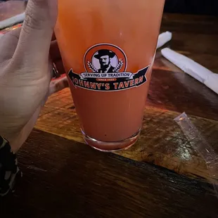 a hand holding a glass of orange juice