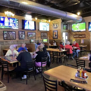 people sitting at tables watching tvs