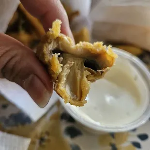 a hand holding a half eaten sandwich