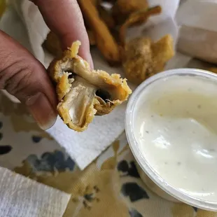 a hand holding a half eaten sandwich