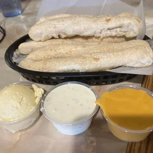 Breadsticks with sides of whipped honey butter, ranch dressing, and nacho cheese.