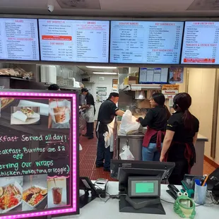 a restaurant with a large menu board