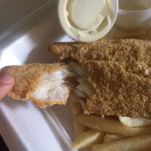 a fish and chips in a styrofoam container