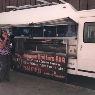 a woman standing in front of a food truck