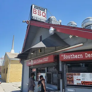 two people standing outside of a restaurant