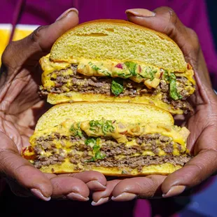 two hands holding a hamburger