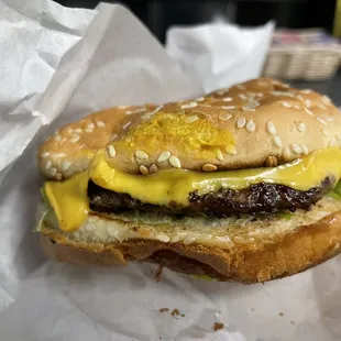 a hamburger with cheese and pickles