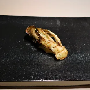 a piece of food on a black plate