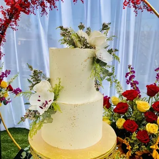 a white wedding cake with fresh flowers