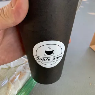 a hand holding a cup of coffee