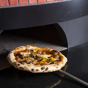 a pizza being taken out of the oven