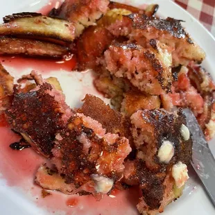 Mini pancakes with strawberry syrup. Bigger than silver dollar. Served on a toast plate. But cooked perfectly.