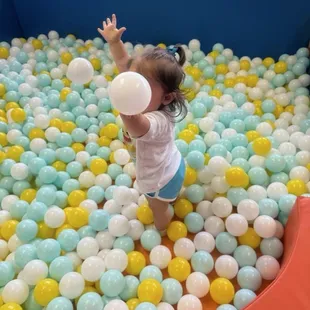 1 year old at play in 2 in under ball pit