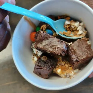 a hand holding a bowl of food