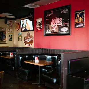 the interior of a restaurant with booths and tables