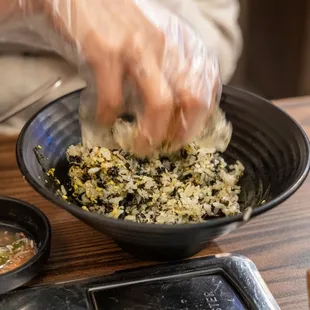 a person putting rice in a bowl