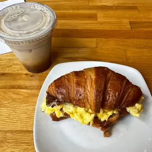 breakfast sandwich on croissant and iced caramel latte with almond milk