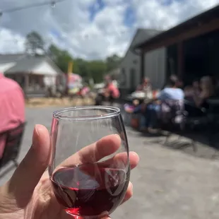 a hand holding a glass of red wine