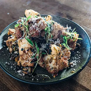 Cauliflower Chilaquiles.  Salsa Verde, cotija cheese, spiced pepita&apos;s, furikake, cilantro.