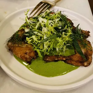 Frog legs with a frisée salad.