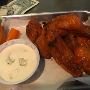 a tray of chicken wings, celery, carrots, and celery sticks