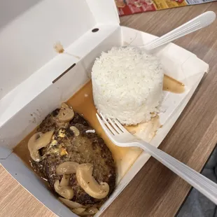 a take out box of food with a fork in it