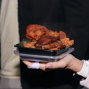 a person holding a tray of food