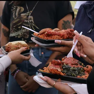 a group of people holding plates of food