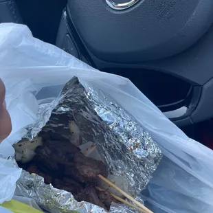 a grilled meat sandwich wrapped in foil