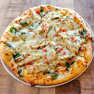 a pizza with chicken and spinach