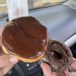 a hand holding a chocolate donut