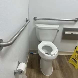 Toilet brush on the floor.