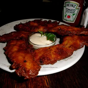 Beer Batter Bacon - peppered bacon dipped in a dark amber + ghost chili batter + fried crisp, served with maple-chive aioli.