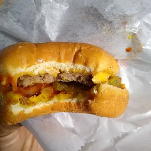 Inside of a burger with everything. Chili, cheese, onion, mustard, and pickle
