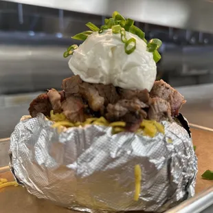 a baked potato with meat and cheese