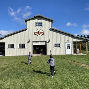 two children playing in front of a barn