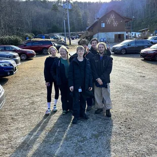 Family shot with lodge and hill in background.