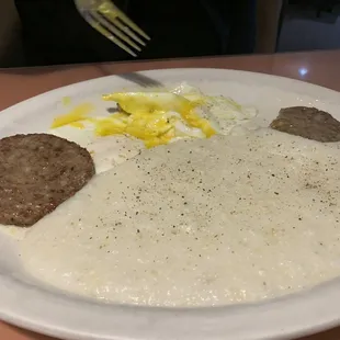 Scrambled eggs, sausage patties and grits
