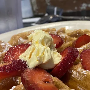 a waffle with strawberries and whipped cream