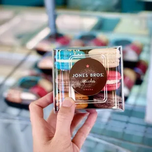 a hand holding a box of cookies