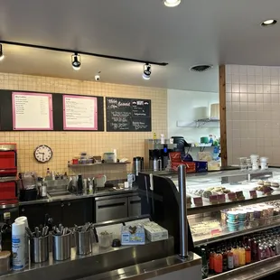 a coffee shop counter with menus on the wall