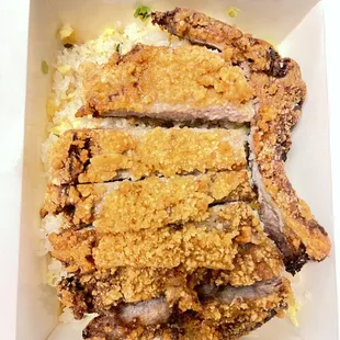 Very well seasoned delicious egg fried rice topped with the flavorful and tender pork chop. Definitely come back for another one.
