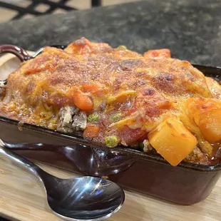 a casserole dish on a table with a spoon