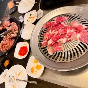 a variety of meats being cooked on a grill
