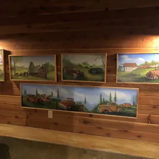 paintings of farm scenes on a wall