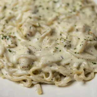 Our decadent Fettucine Alfredo with homemade pasta and sauce, pictured here with our Italian seasoned chicken.