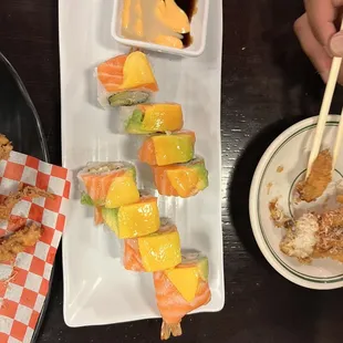 a plate of sushi and a bowl of sauce