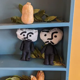 two dolls on a shelf