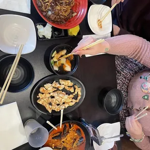 a woman eating a meal with chopsticks